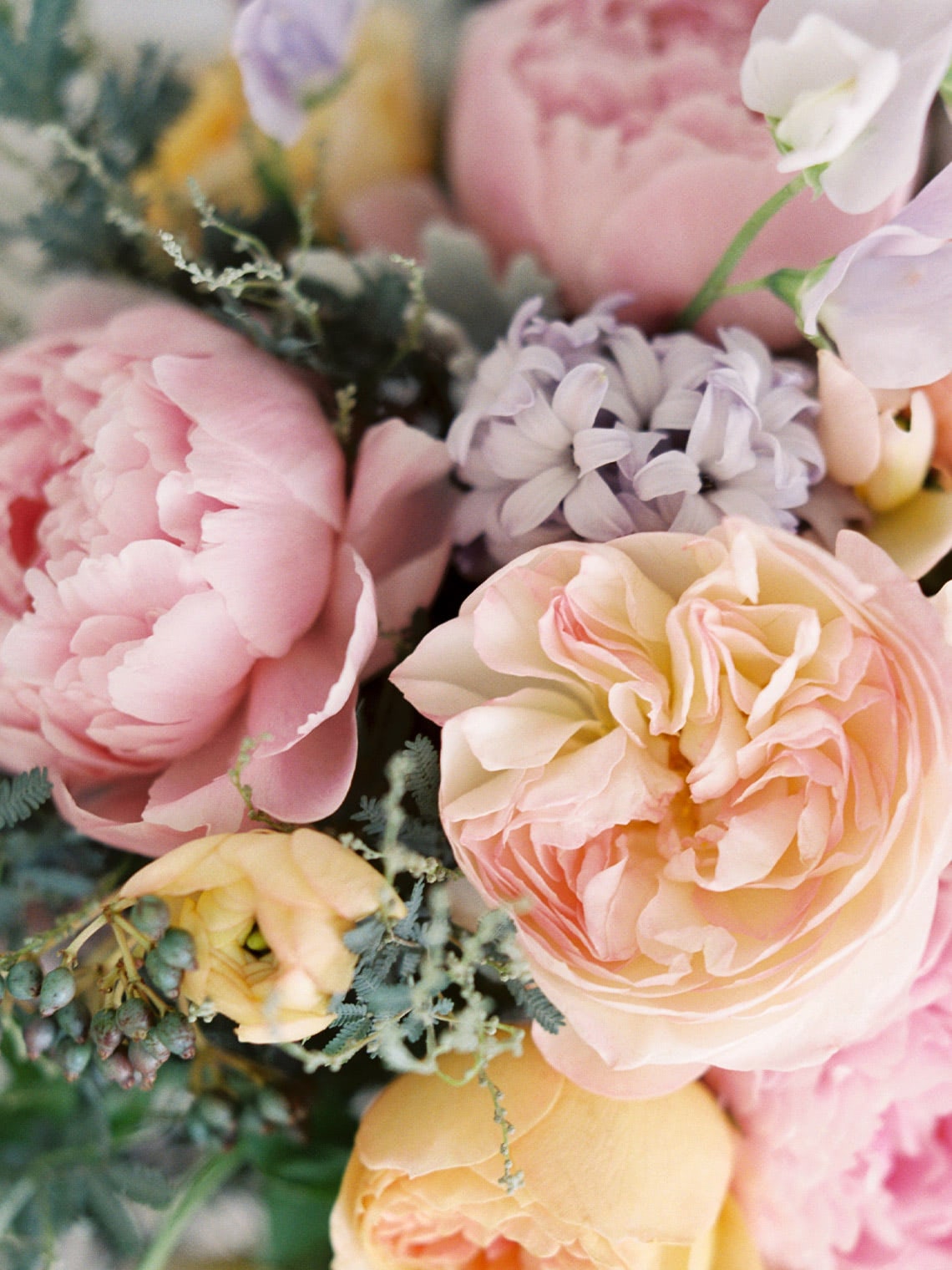 Close-up of blush garden roses, pink peonies, hyacinths, and soft spring flowers in a pastel bouquet