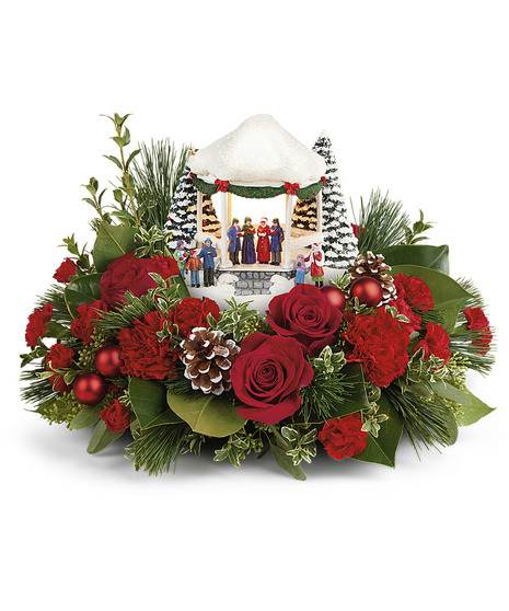 holiday centerpiece with red flowers and thomas kinkade keepsake figurine