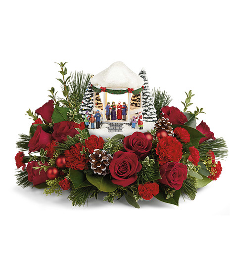 holiday centerpiece with red flowers and thomas kinkade keepsake figurine