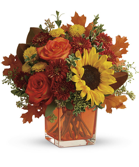 autumnal flowers in orange cube vase