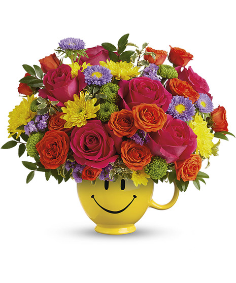 colorful floral arrangement in smiley mug